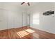 Bedroom with laminated wood floor, closet, and fixture for mounting a television at 1441 N 80Th Ln, Phoenix, AZ 85043