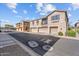 Townhome exterior with attached garages, balconies, and manicured landscaping at 1441 N 80Th Ln, Phoenix, AZ 85043