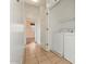 Hallway with tiled floors leads to the laundry area with a white washer and dryer at 1441 N 80Th Ln, Phoenix, AZ 85043