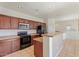 Practical kitchen layout with dark cabinets, complete appliance package, and breakfast bar at 1441 N 80Th Ln, Phoenix, AZ 85043