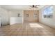 Spacious living room with neutral paint, tile flooring, a ceiling fan, and multiple windows for natural light at 1441 N 80Th Ln, Phoenix, AZ 85043