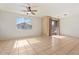 Bright living room featuring tile floors, large window, slider to deck, and ceiling fan at 1441 N 80Th Ln, Phoenix, AZ 85043