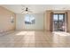 Bright living room featuring tile floors, slider to deck, ceiling fan and natural light at 1441 N 80Th Ln, Phoenix, AZ 85043