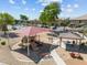 Community playground featuring shade structures, play equipment, and walking paths at 1441 N 80Th Ln, Phoenix, AZ 85043