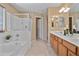 Bright bathroom featuring a glass-enclosed shower and a separate soaking tub at 15046 W Post Dr, Surprise, AZ 85374