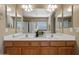 Bathroom featuring dual sinks, oak cabinets, framed mirrors and vanity lighting at 15046 W Post Dr, Surprise, AZ 85374