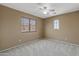 Neutral bedroom featuring plush carpet, ceiling fan and bright window at 15046 W Post Dr, Surprise, AZ 85374