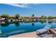 Picturesque backyard view with waterfront, lounge chairs, and lovely home exteriors on a sunny day at 20119 N Laguna Way, Maricopa, AZ 85138