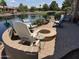 Waterfront backyard with a fire pit and outdoor seating creating a cozy and inviting outdoor space at 20119 N Laguna Way, Maricopa, AZ 85138
