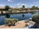 Waterfront backyard with a brick patio, lake view and outdoor seating perfect for relaxing at 20119 N Laguna Way, Maricopa, AZ 85138