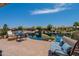 Waterfront backyard with a brick patio, outdoor seating, lush landscaping and tranquil water views at 20119 N Laguna Way, Maricopa, AZ 85138