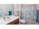 Bright bathroom with white vanity, a toilet and a shower with a seashell-themed shower curtain at 20119 N Laguna Way, Maricopa, AZ 85138