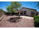 Well-maintained backyard featuring a paved patio, decorative rock landscaping, and mature trees at 20443 N 39Th Dr, Glendale, AZ 85308