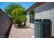 A small backyard with decorative rock, an air conditioning unit, and a view of mature foliage at 20443 N 39Th Dr, Glendale, AZ 85308
