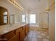 Bright bathroom with double sinks, soaking tub under window, and a glass-enclosed shower at 20443 N 39Th Dr, Glendale, AZ 85308