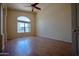 Well-lit living room with hardwood floors, ceiling fan, and a large arched window at 20443 N 39Th Dr, Glendale, AZ 85308
