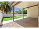 Relaxing covered back patio, perfect for outdoor living, with views of the grassy yard and lush palm trees at 2137 E New Bedford Dr, Gilbert, AZ 85234