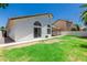 A backyard showing ample green space, a covered patio, privacy landscaping, and a view of the home's architecture at 2137 E New Bedford Dr, Gilbert, AZ 85234
