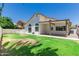 Backyard showcases lawn space, a covered patio with a ceiling fan, and sliding glass doors leading into the home at 2137 E New Bedford Dr, Gilbert, AZ 85234