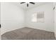 Bright bedroom featuring carpet flooring, neutral paint, a ceiling fan, and a large window at 2137 E New Bedford Dr, Gilbert, AZ 85234