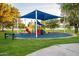 Outdoor playground with a large shade structure, slides, and green space at 2137 E New Bedford Dr, Gilbert, AZ 85234