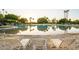 Resort style swimming pool with beach entry and rows of lounge chairs overlooking the serene water at 2137 E New Bedford Dr, Gilbert, AZ 85234
