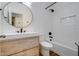 Modern bathroom featuring a wood vanity, round mirror, and a subway-tiled tub and shower at 2203 E Crest Ln, Phoenix, AZ 85024