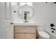 Bright bathroom featuring a round mirror, modern vanity, and tub-shower combo with a subway tile backsplash at 2203 E Crest Ln, Phoenix, AZ 85024