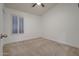 Cozy bedroom with neutral carpet, a ceiling fan, and a window with wooden shutters at 2203 E Crest Ln, Phoenix, AZ 85024