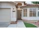 Close-up of a home's front entrance, highlighting the door, stylish lighting, and manicured landscaping at 2203 E Crest Ln, Phoenix, AZ 85024