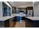 Modern kitchen featuring dark cabinets, stainless steel appliances, countertops, and wood-look tile flooring at 2203 E Crest Ln, Phoenix, AZ 85024