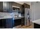 Modern kitchen featuring dark cabinets, stainless steel appliances, countertops, and wood-look tile flooring at 2203 E Crest Ln, Phoenix, AZ 85024