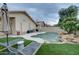 Inviting backyard pool with rock waterfall, lush artificial turf, and comfortable lounge chairs at 2203 E Crest Ln, Phoenix, AZ 85024