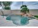 Sparkling backyard pool with a rock waterfall feature and lush landscaping for a relaxing outdoor experience at 2203 E Crest Ln, Phoenix, AZ 85024