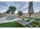 Backyard oasis with a beautiful pool, rock waterfall feature, lush landscaping, and poolside seating at 2203 E Crest Ln, Phoenix, AZ 85024