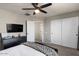 Spacious bedroom featuring a low-profile platform bed, TV, sliding closet doors, and neutral tones at 3123 E Buena Vista Dr, Chandler, AZ 85249