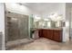 An elegant bathroom featuring double sinks with dark wood cabinets and a tiled glass shower at 31502 N 58Th Pl, Cave Creek, AZ 85331