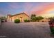 Single story desert home with neutral colored stucco and gravel landscaping at sunset at 31502 N 58Th Pl, Cave Creek, AZ 85331