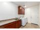 Functional laundry room with sink, cabinets and modern white appliances at 31502 N 58Th Pl, Cave Creek, AZ 85331