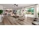 Bright living room featuring hardwood floors, large windows, stylish seating, and adjacent kitchen and dining area at 31502 N 58Th Pl, Cave Creek, AZ 85331