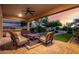 Covered patio with comfortable seating, ceiling fan, and view of the lush backyard landscaping at 31502 N 58Th Pl, Cave Creek, AZ 85331