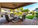 Inviting covered patio featuring comfortable seating, an outdoor kitchen, and a serene view of the backyard at 31502 N 58Th Pl, Cave Creek, AZ 85331