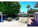 Backyard with a large shade tree, green shrubbery, and a canoe on a small deck at 3202 W Joan De Arc W Ave, Phoenix, AZ 85029