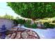Backyard featuring a large tree, rocks, lush greenery, a wall, and a stone pathway at 3202 W Joan De Arc W Ave, Phoenix, AZ 85029