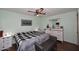 Bright bedroom featuring a ceiling fan, a bed with a black and white blanket, and a wooden floor at 3202 W Joan De Arc W Ave, Phoenix, AZ 85029