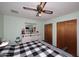 Bedroom with a ceiling fan, a bed with a black and white blanket, and two wooden closets at 3202 W Joan De Arc W Ave, Phoenix, AZ 85029