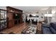 Open concept living area with hardwood floors, a large entertainment center, and an adjacent kitchen at 3202 W Joan De Arc W Ave, Phoenix, AZ 85029