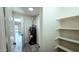 Hallway view of a home's utility closet, equipped with shelves, and has a water heater at 3708 W Peoria Ave, Phoenix, AZ 85029