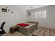 Modest bedroom with wood-look tile floors, one window, and a red blanket atop the bed at 4026 W Berridge W Ln, Phoenix, AZ 85019