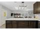 Bright kitchen featuring dark cabinets, a white countertop island, and modern light fixtures at 4026 W Berridge W Ln, Phoenix, AZ 85019